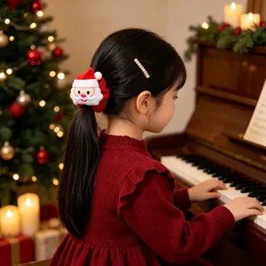 Detail van een meisje met een pluche kerstman-scrunchie van fluweel bij een piano
