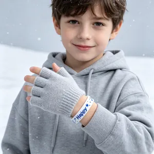 Detail van witte siliconen armband met blauwe Happy-tekst gedragen door kind in de sneeuw