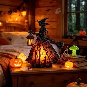 Vue détaillée d'une lampe sorcière en résine avec robe à motifs d'arbres sur une table de nuit.