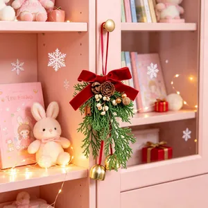 Detailweergave van een kerstguirlande met rode strik, dennenappels en gouden bellen