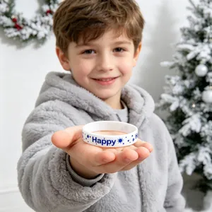 Kleine jongen met een witte siliconen kerstarmband met blauwe vrolijke kerstpatronen