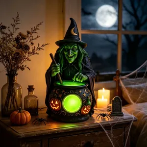 Statue de sorcière d'Halloween avec chaudron vert et accents de citrouilles