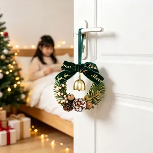 Detailweergave van een mini-kerstkrans met groene fluwelen strik en gouden bel
