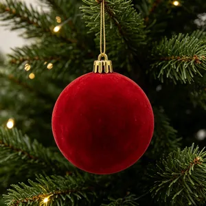 Vista dettagliata di una pallina di Natale rossa floccata appesa a un albero di pino.