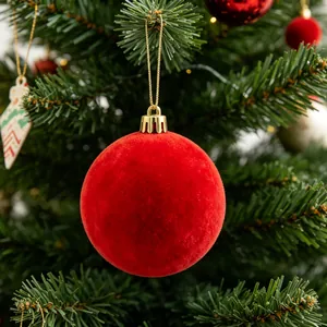 Primo piano di una palla di Natale rossa floccata appesa a un albero di Natale festivo