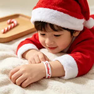 Close-up van een kind met een witte kerst siliconen polsband met feestelijke rode tekst