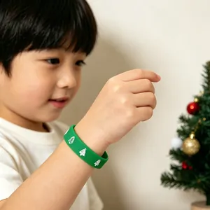 Close-up van een kind met een groene siliconen kerstpolsband met boommotieven