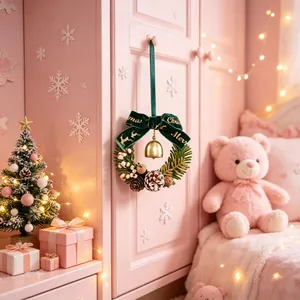 Detailopname van een kerstkrans met een groene fluwelen strik en gouden belletje