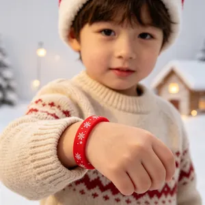 Detail van een rode kerst siliconen armband met sneeuwvlokken op een kinderpols