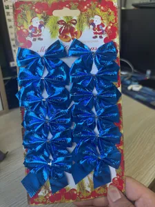 Macro view of 12 metallic blue Christmas bows on a decorative cardboard package