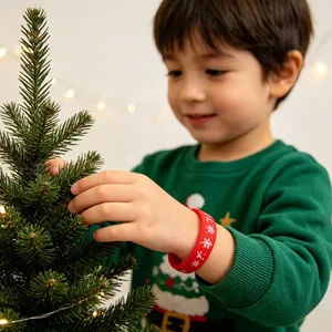 Rode kerst siliconen armband met sneeuwvlokprint gedragen door een klein kind