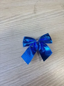 Detailed macro view of a shiny mini blue metallic Christmas bow on wooden background