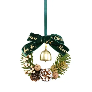 Kerstkrans versiering met groene fluwelen strik, gouden bel en dennenappels voor de boom.
