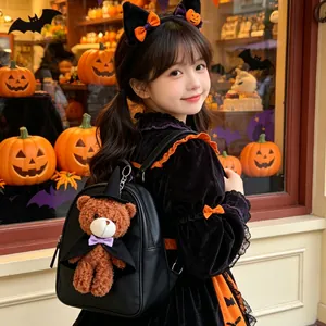 Ciondolo zaino in peluche orsetto di Halloween su uno zaino nero indossato da una ragazza.