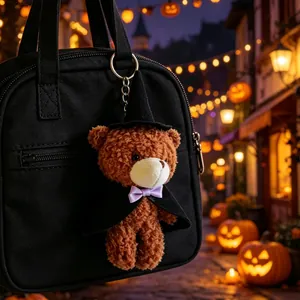 Primo piano di un portachiavi con orsetto di Halloween in costume da strega su una borsa.