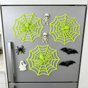 Detailed view of neon green spider web and spooky magnets on a gray refrigerator.