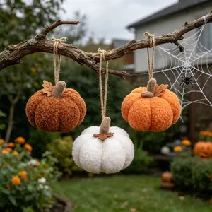 Detailed macro view of plush textured hanging pumpkins in brown, white and orange colors