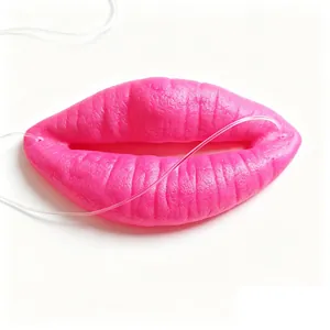 Close-up detail view of hot pink sausage lips prop with textured finish and elastic straps