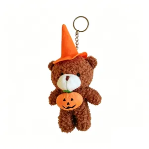 Dettaglio ravvicinato di un portachiavi a forma di orsetto di peluche con cappello da mago e zucca.