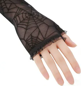 Close-up detail of black spiderweb patterned lace fingerless gloves with elegant ruffles