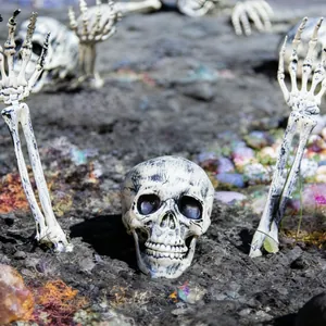 Detailaufnahme eines realistischen Halloween-Schädels und Skeletthänden für den Garten