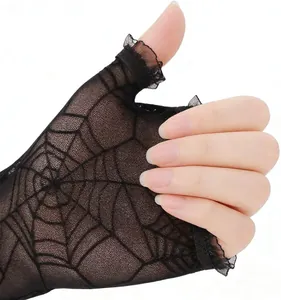 Close-up of black lace spiderweb fingerless glove with delicate ruffle edge.