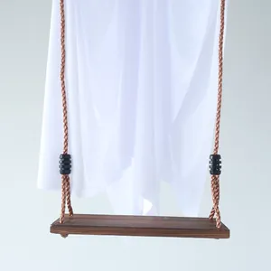 Detail of white fabric Halloween ghost hanging on a wooden swing seat