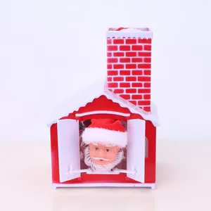 Close-up of electric Christmas Santa Claus ornament inside a red and white plastic house