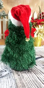 Detailed view of the red Santa hat with a gold bell on a green electric Christmas toy