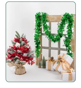 Detail view of vibrant green and red Christmas tinsel garlands in a festive scene