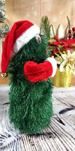 Detail view of 30cm electric dancing Christmas tree toy in Santa hat.