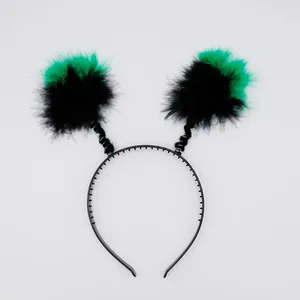 Détail d'un serre-tête d'Halloween avec des pompons en plumes vertes et noires
