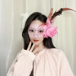 Detailansicht eines Modells mit einer rosa Spitzenmaske, großer Blume und Federn