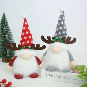 Cute Christmas gnomes with reindeer antlers and polka dot hats on a festive white surface