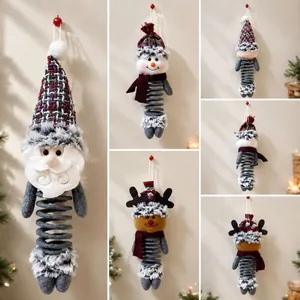 Dettaglio di ornamenti natalizi in peluche con gambe a molla e cappelli a maglia