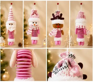 Dettaglio di ornamenti natalizi in peluche con gambe a molla rosa e cappelli a maglia