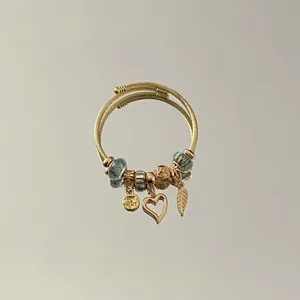 Close-up detail of an adjustable stainless steel charm bracelet with golden heart charm