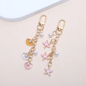 Vue détaillée de porte-clés thème marin avec étoiles de mer, coquillages et perles.
