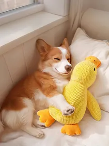 Corgi dog comfortably hugging a plush yellow duck toy while sleeping on a soft white bed