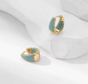 Dettaglio ravvicinato di orecchini a cerchio a goccia placcati in oro 18K con turchesi