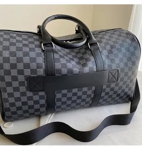 Nahaufnahme der Reisetasche mit Karomuster, robusten Griffen und Nähtedetails.