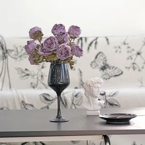 Elegant vintage purple artificial roses in a sleek black goblet vase for home decor