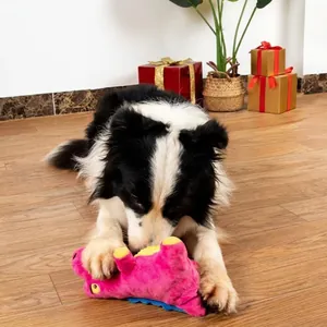 Durable squeaky pink dinosaur plush dog toy shown with a dog playing in a cozy room