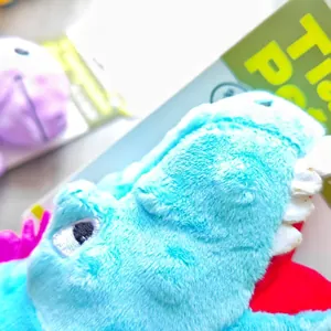 Blue dinosaur squeaky plush dog toy with soft texture and white teeth for chewing.