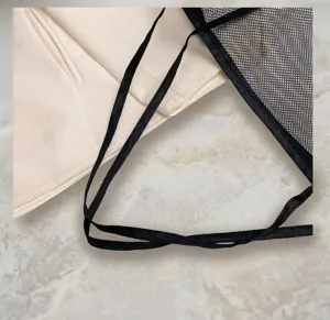 Primo piano della resistente tracolla nera su una borsa a rete per viaggi e spiaggia
