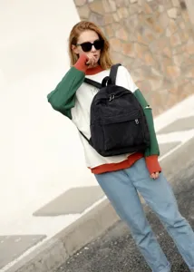 Modischer schwarzer Cord-Rucksack für Damen, präsentiert von einem Model im Freien