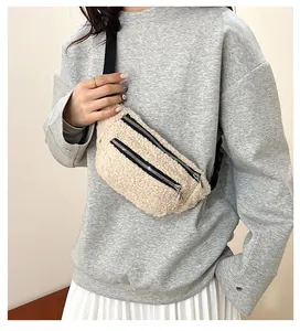 Detailed view of a beige fuzzy plush chest bag worn by a model over a grey sweatshirt
