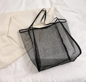 Grande borsa a rete nera da spiaggia con tablet e telefono per confronto dimensioni