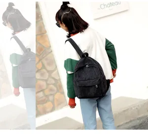Frau trägt einen lässigen schwarzen Cord-Rucksack für Schule oder Alltag im Freien