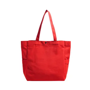 Detailed view of the red canvas tote bag with top snap closure and side pockets